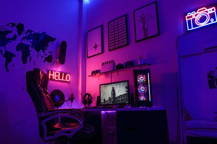 Una PC para juegos de alta gama con iluminación RGB situada sobre un escritorio en una habitación bien iluminada, rodeada de periféricos y decoraciones para juegos.