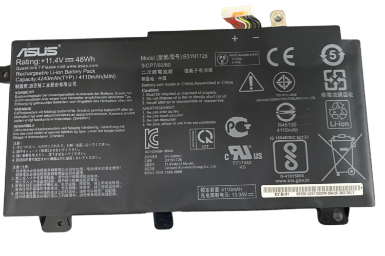 Imagen de una batería de computadora portátil Asus Fx505 hinchada con hinchazón y deformación visibles.