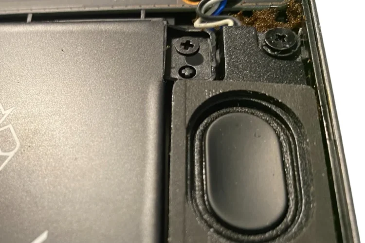 Una foto de primer plano del altavoz de una computadora portátil Xiaomi que se rompió, no suena, no funciona