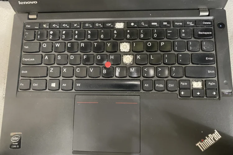 Teclas faltantes en el teclado de una computadora portátil Lenovo ThinkPad, lo que muestra la necesidad de reparación o reemplazo.
