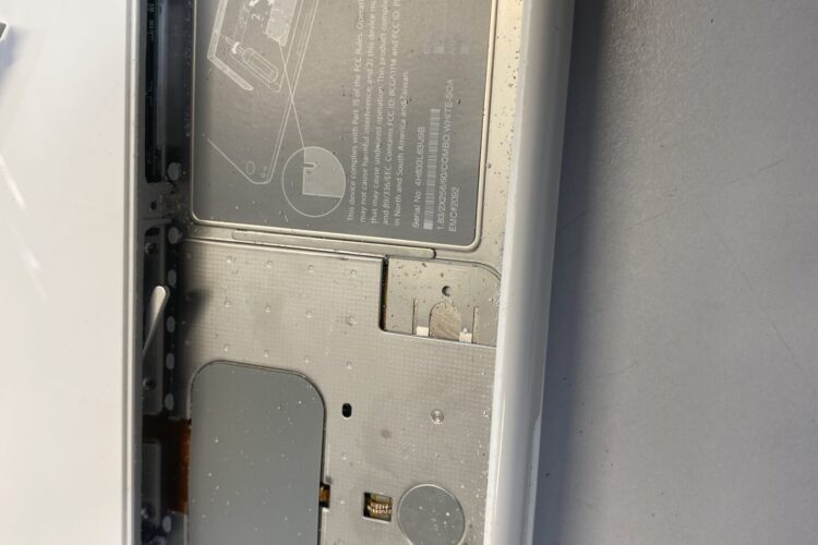 Una foto de primer plano de la batería de una MacBook que muestra signos de corrosión y daños.