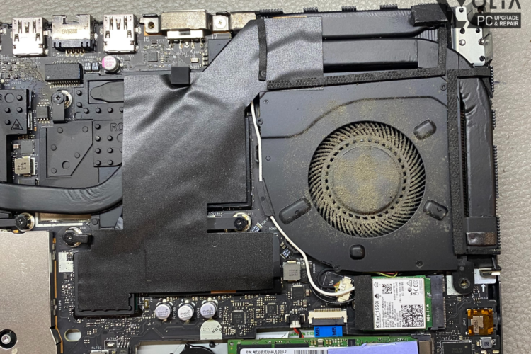 Image of a Lenovo laptop with a cooling fan heavily covered in dust, illustrating a year's worth of dust accumulation without cleaning